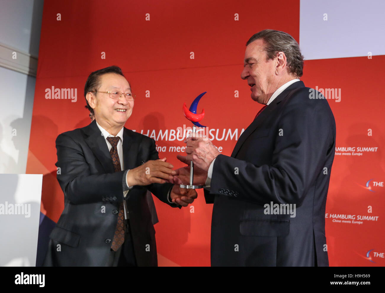 (161123) - Hambourg (Allemagne), le 23 novembre 2016 (Xinhua) -- le président d'honneur de la Chine "Sommet de Hambourg à la rencontre de l'Europe" et l'ancien chancelier allemand Gerhard Schroeder (R) reçoit un trophée de la Médaille de l'Amitié de la Chine Li Yizhong, président de Chine Russie de l'économie industrielle, au cours de la septième Sommet de Hambourg 'Chine' à la rencontre de l'Europe à Hambourg, Allemagne du nord, le 23 novembre 2016. Le septième Sommet de Hambourg 'Chine' a ouvert la rencontre de l'Europe ici mercredi, le dessin des hauts fonctionnaires, des entrepreneurs et des universitaires de la Chine et l'Union européenne (UE) pour discuter de la plus importan Banque D'Images