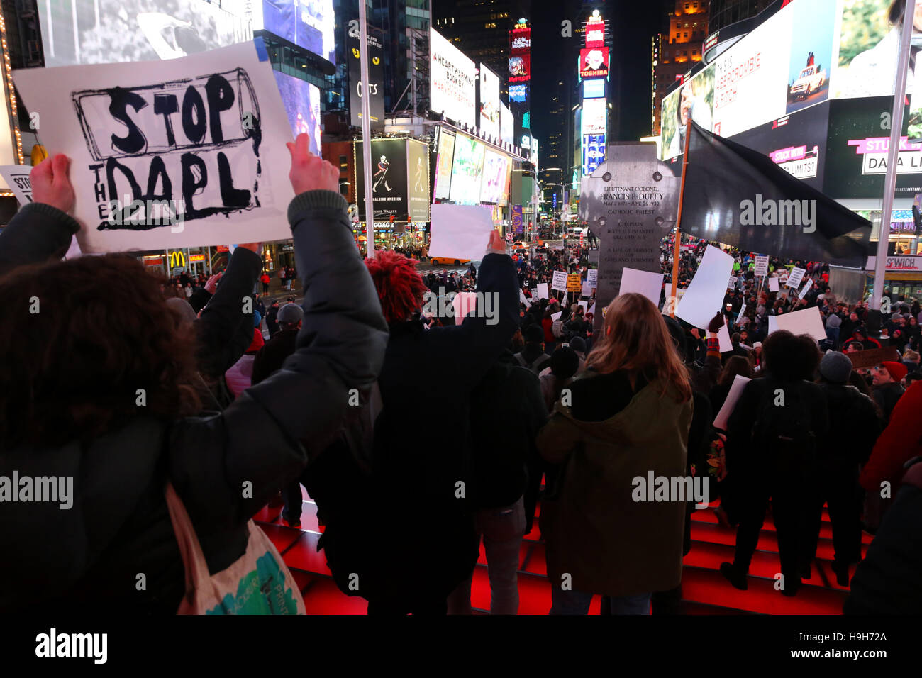 New York, USA. 23 novembre, 2016. Militants sur les étapes de la rouge stand TKTS à Times Square, New York City. Manifestants rassemblés là en solidarité en réaction aux récents événements de Standing Rock (Dakota du Nord), et de s'opposer à la construction de la Pipeline Accès Dakota. Banque D'Images