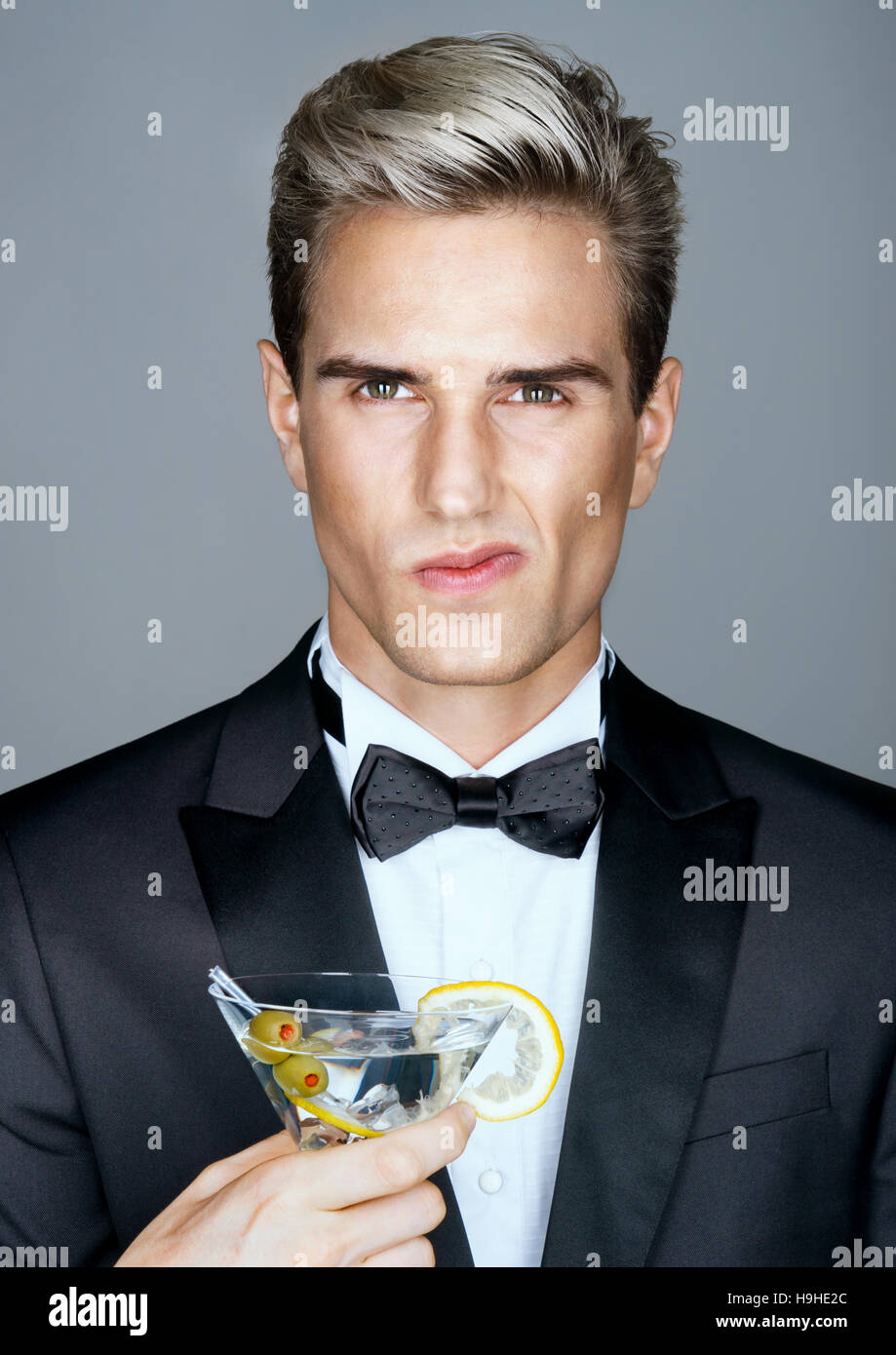 Homme riche mécontents avec verre de martini. Photo de l'homme élégant en costume noir élégant. Grande Vie Banque D'Images