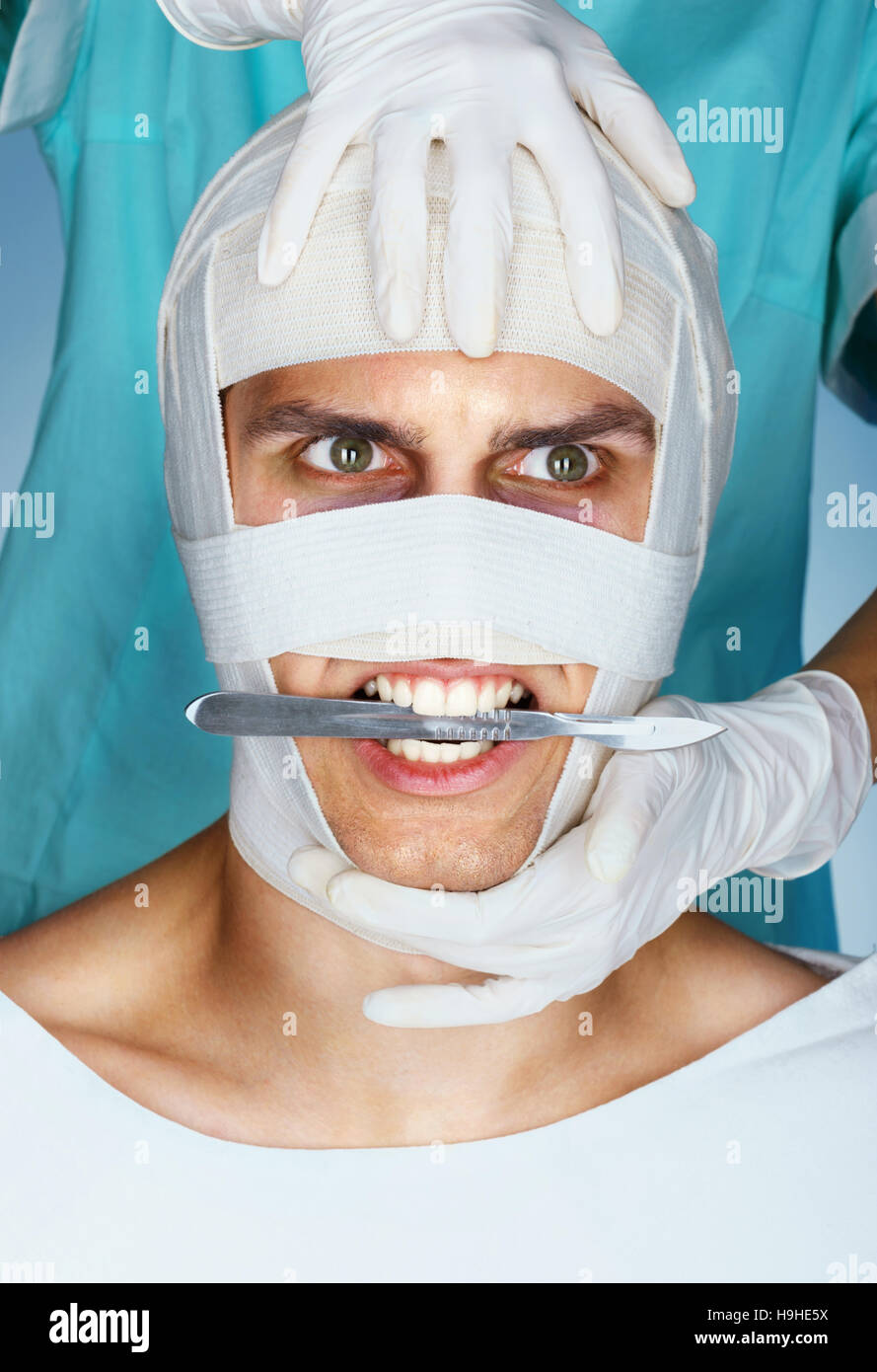Beauté furieuse victime avec un scalpel dans sa bouche. Médecin de la chirurgie en plastique avec le patient en bandage médical après l'opération. Banque D'Images
