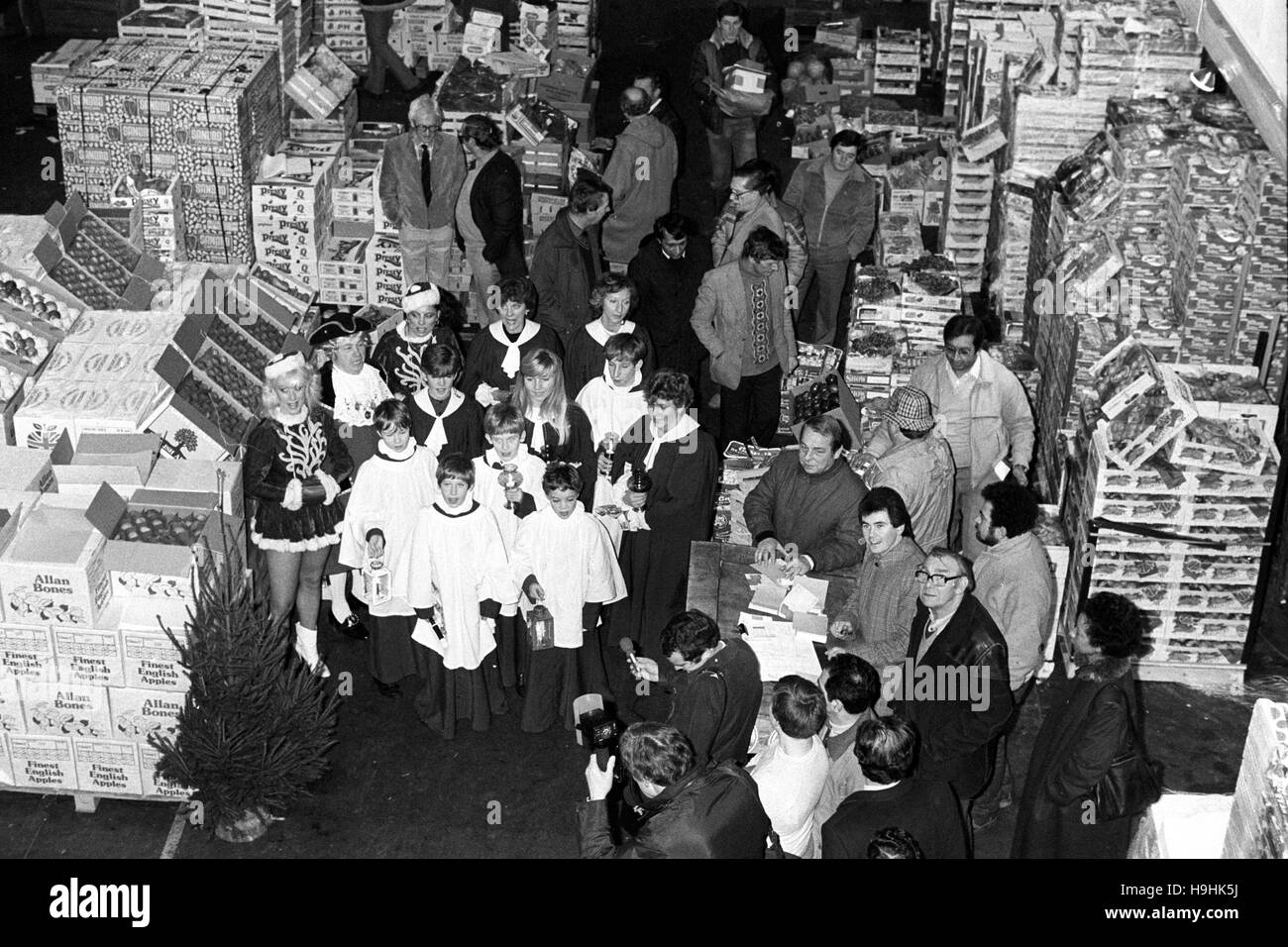 Une chorale d'enfants de la région de Kent apple faire l'ancienne coutume de l'anglais 'Wassailing" - le don de pommes à Noël - au nouveau marché couvert de Covent Garden, Londres. Banque D'Images