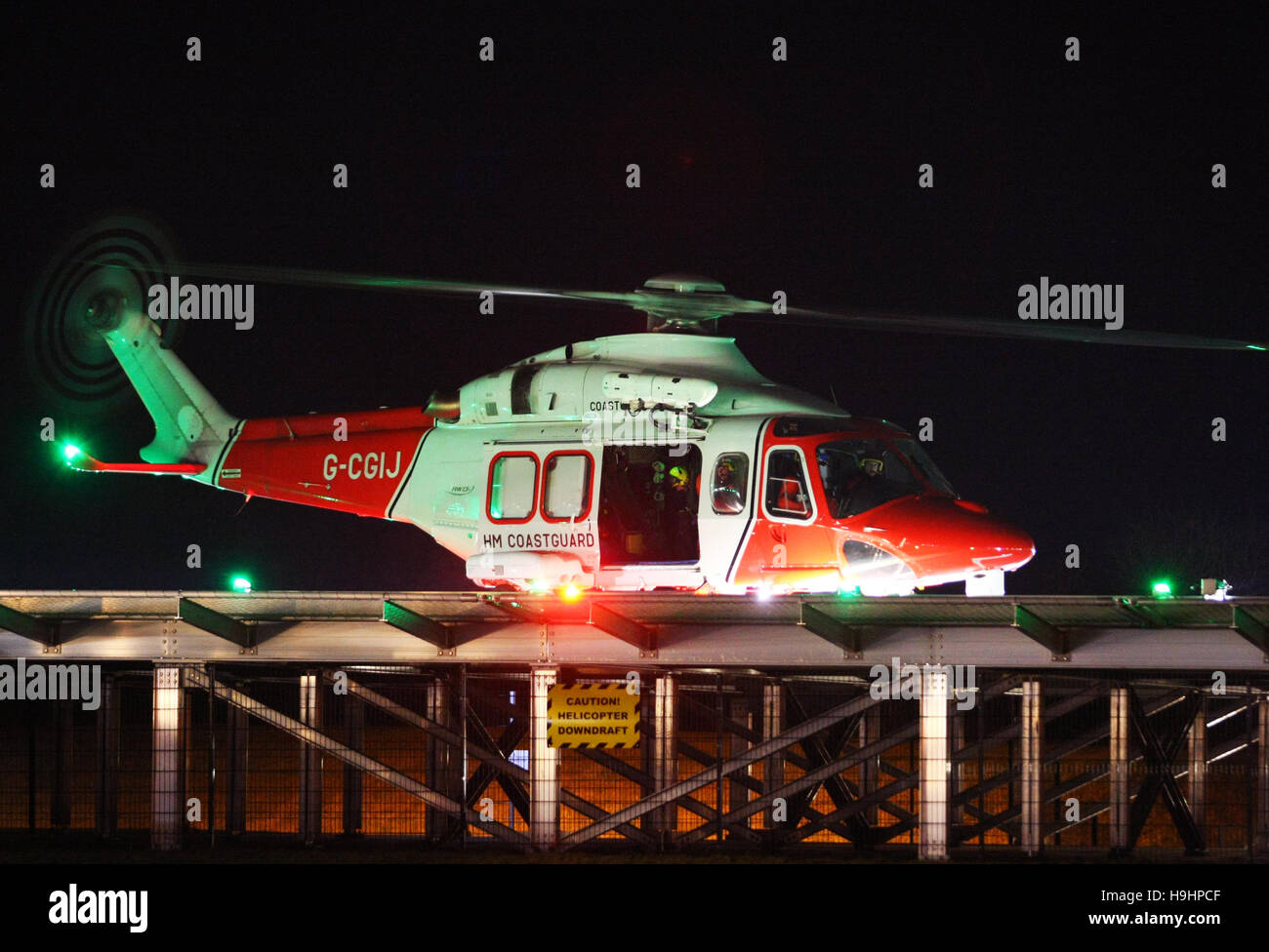 HM Hélicoptère de recherche et sauvetage de la Garde côtière 104 atterrit sur un héliport au St Mary's Hospital sur l'île de Wight dans la nuit Banque D'Images