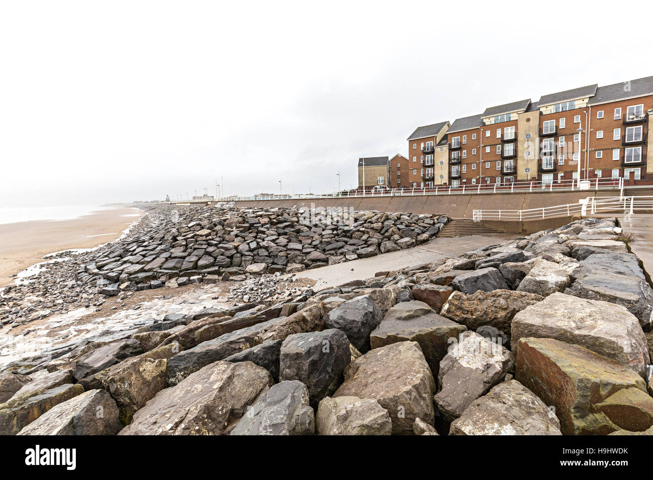 Plage et de protection de la rive avec de grosses roches en face de maisons du front de mer, Aberavon, Pays de Galles, Royaume-Uni Banque D'Images