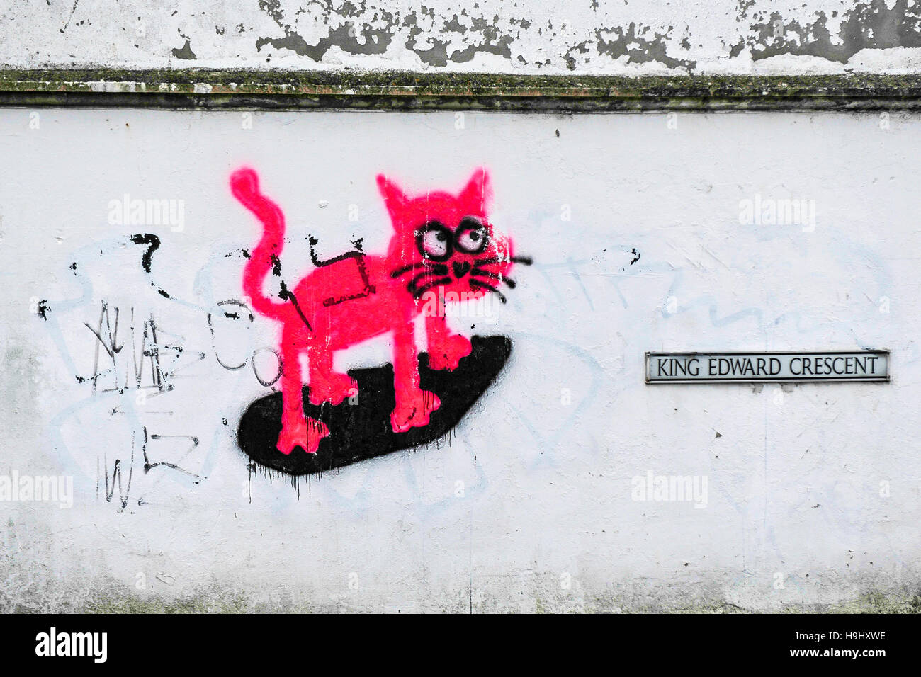 Graffiti - un dessin animé chat rose pulvérisé sur un mur. Banque D'Images