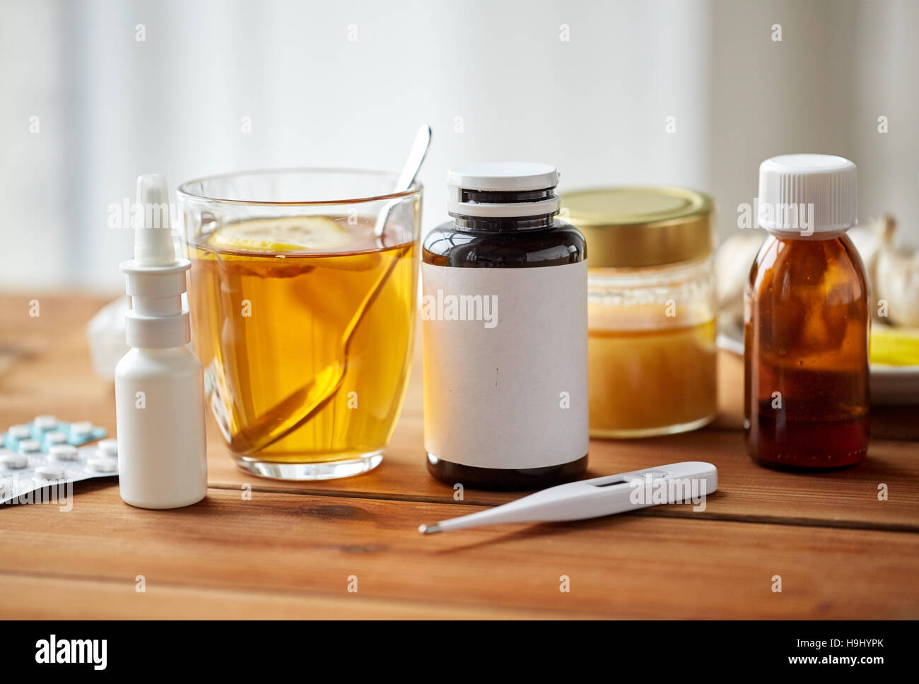 La drogue, thermomètre, le miel et une tasse de thé sur bois Banque D'Images