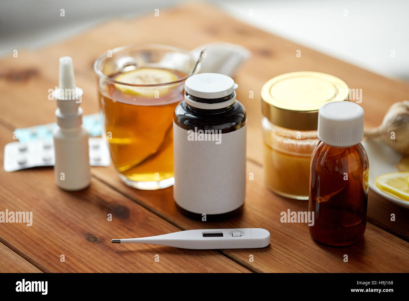 La drogue, thermomètre, le miel et une tasse de thé sur bois Banque D'Images