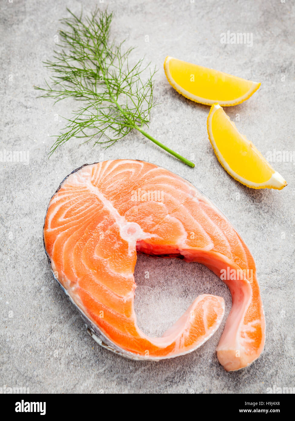 Filet de saumon frais tranche sur pierre sombre arrière-plan avec le fenouil Banque D'Images