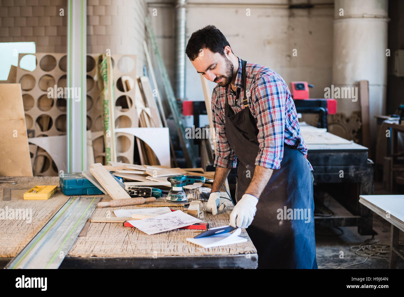 Portrait d'un charpentier bois debout dans son studio et holding digital tablet Banque D'Images