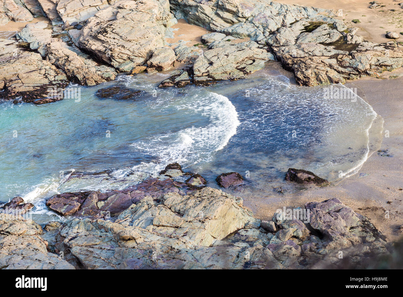 Vagues se brisant dans une petite crique rocheuse sur la côte nord de la Cornouailles. Banque D'Images