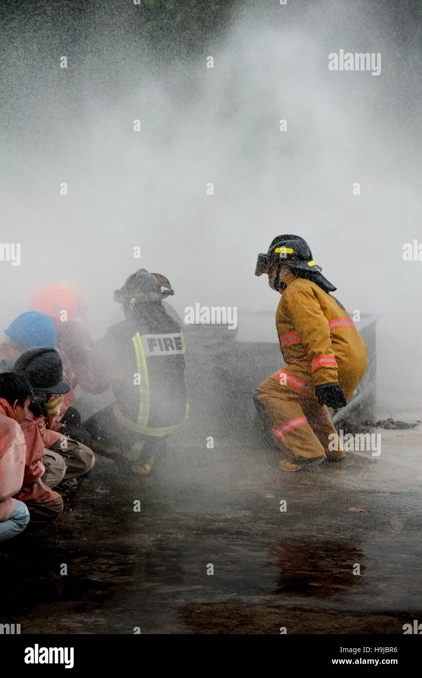 Pompiers lutter contre un feu faisant rage avec d'immenses flammes de bois brûlant Banque D'Images