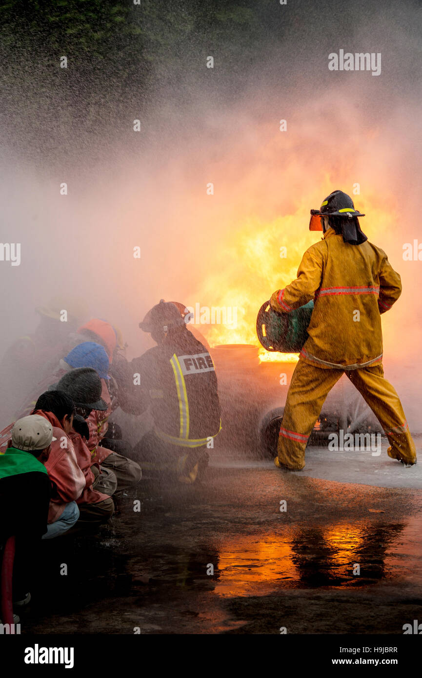 Pompiers lutter contre un feu faisant rage avec d'immenses flammes de bois brûlant Banque D'Images