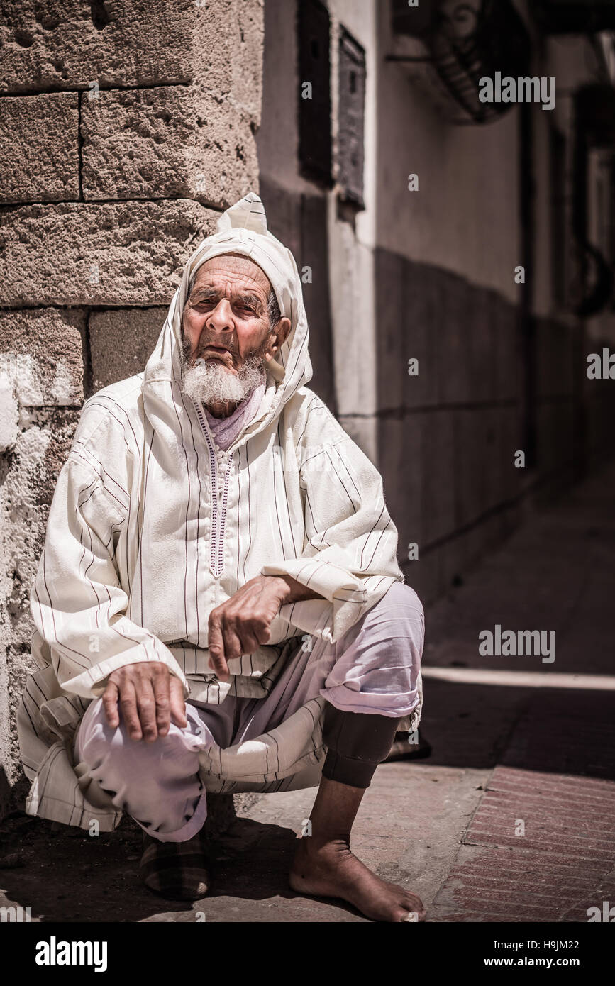 Un portrait photographique d'une vieille tradition de l'homme marocain traditionnel assis vêtements dans une rue au Maroc, Marrakech Banque D'Images