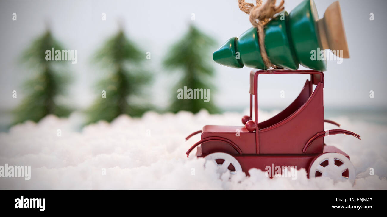 Toy voiture transportant arbre de Noël sur neige artificielle Banque D'Images