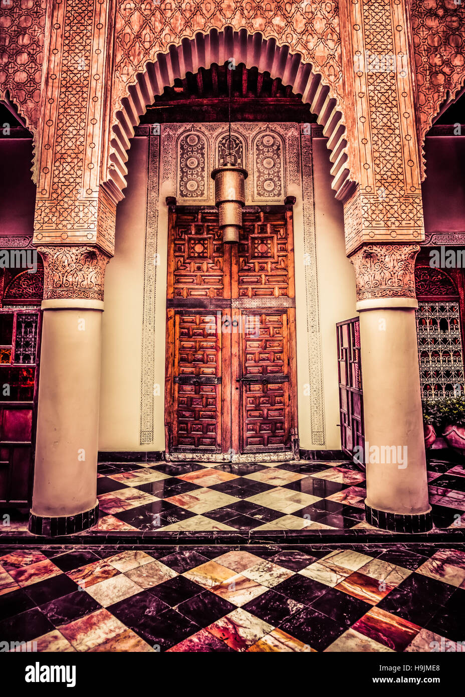 Grande porte traditionnelle marocaine et de la lanterne dans un riad, Marrakech, Maroc en cour Banque D'Images