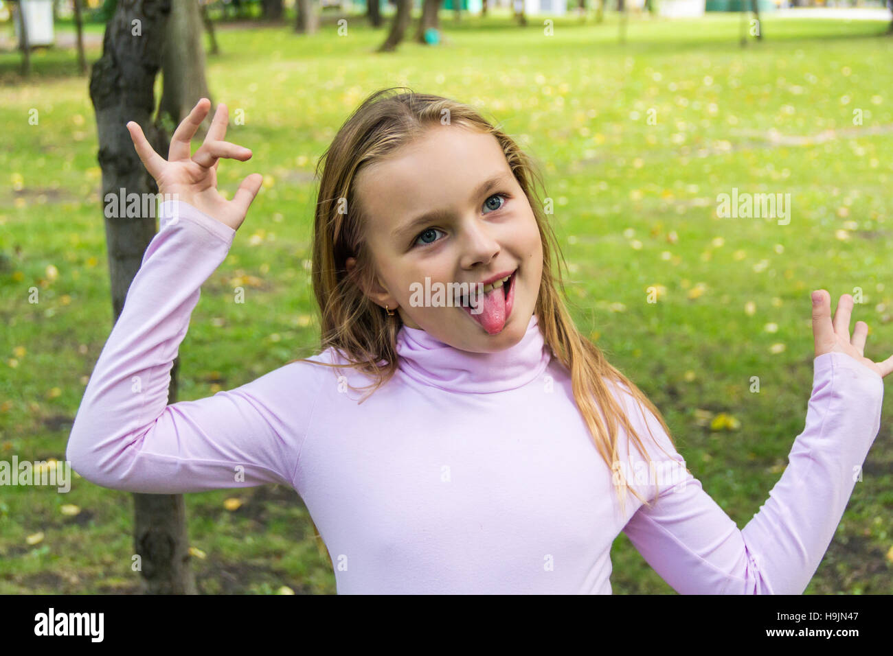 Portrait de fille mignonne avec mettre out tongue Banque D'Images