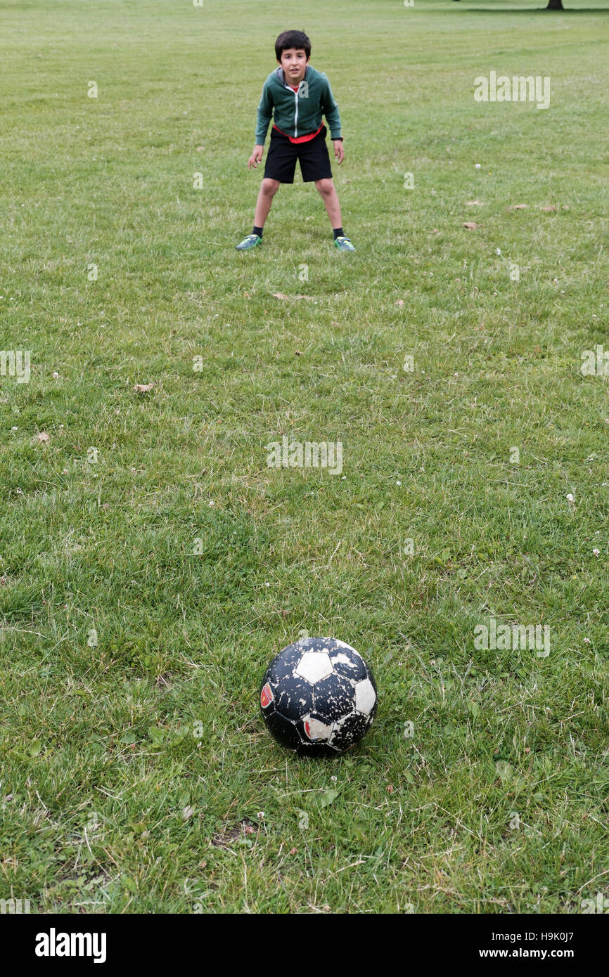 Garçon 8-9 ans,joue au football Banque D'Images