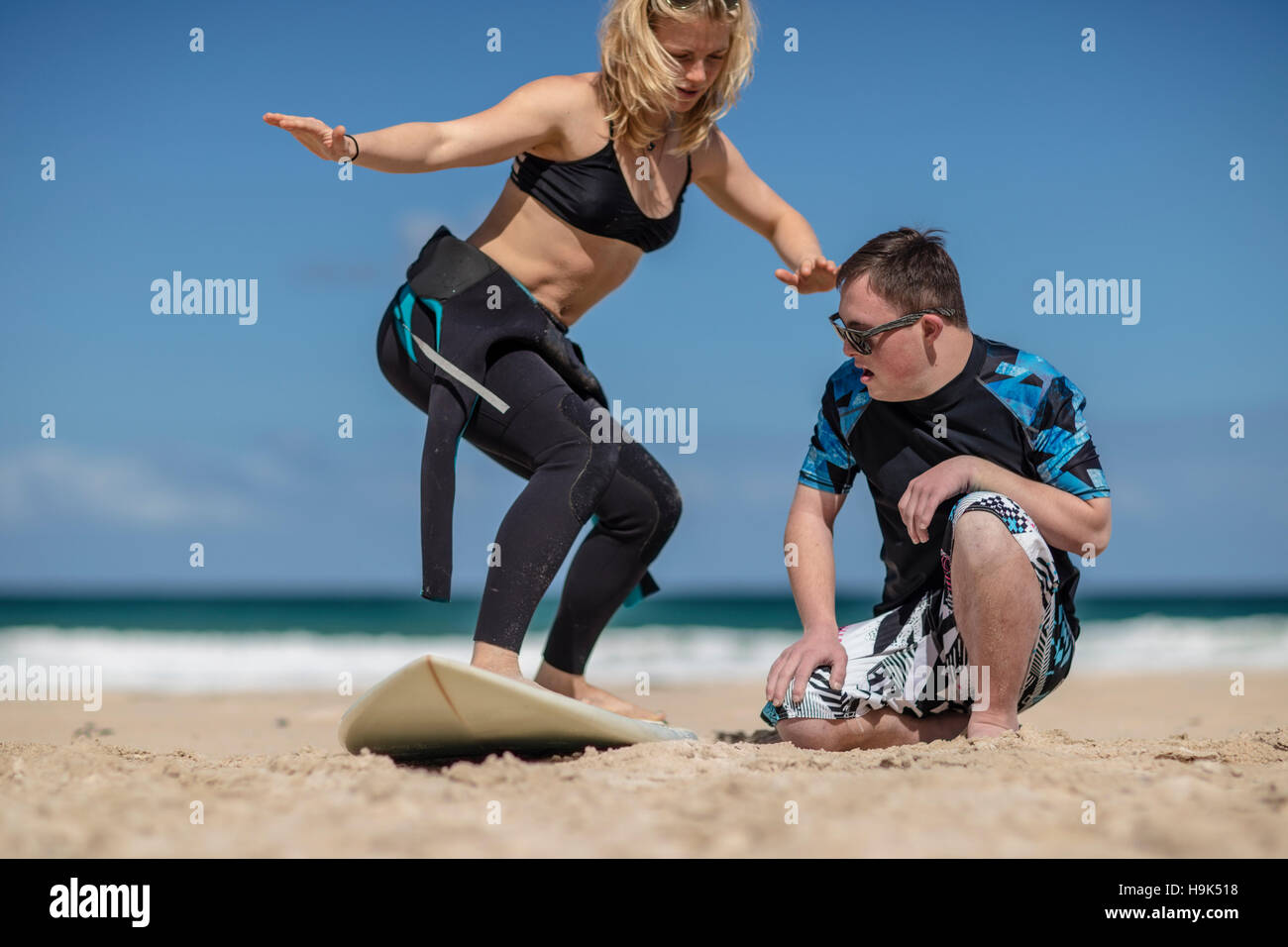 Teenage boy with down syndrome ayant cours de surf sur la plage Banque D'Images