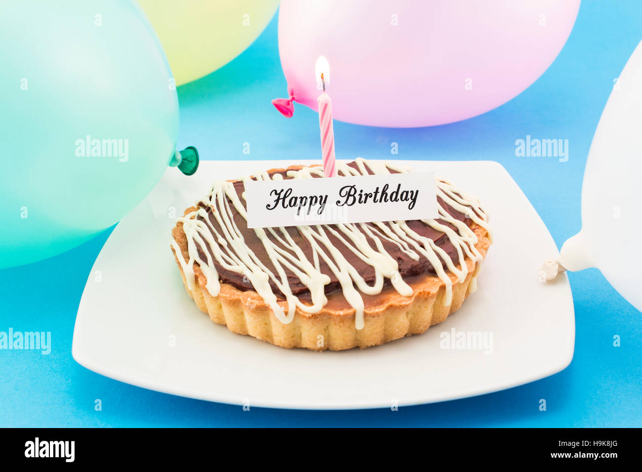 Joyeux Anniversaire Carte de souhaits avec Tart, bougie et de ballons. Banque D'Images