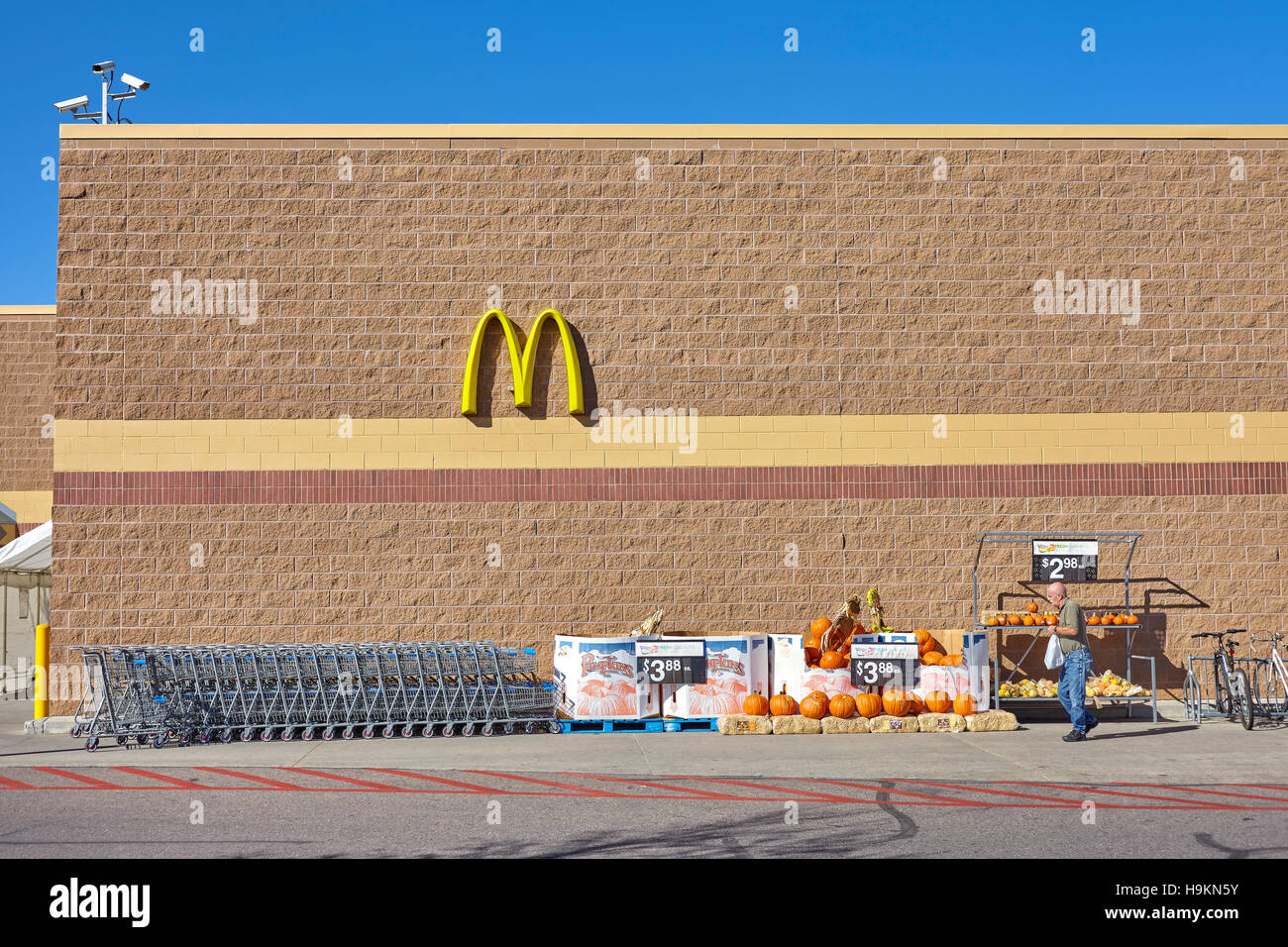 Denver, États-Unis - 16 octobre 2016 : homme non identifié laissant magasin Walmart, McDonald's visible et logo Halloween citrouilles décoratives vente. Banque D'Images