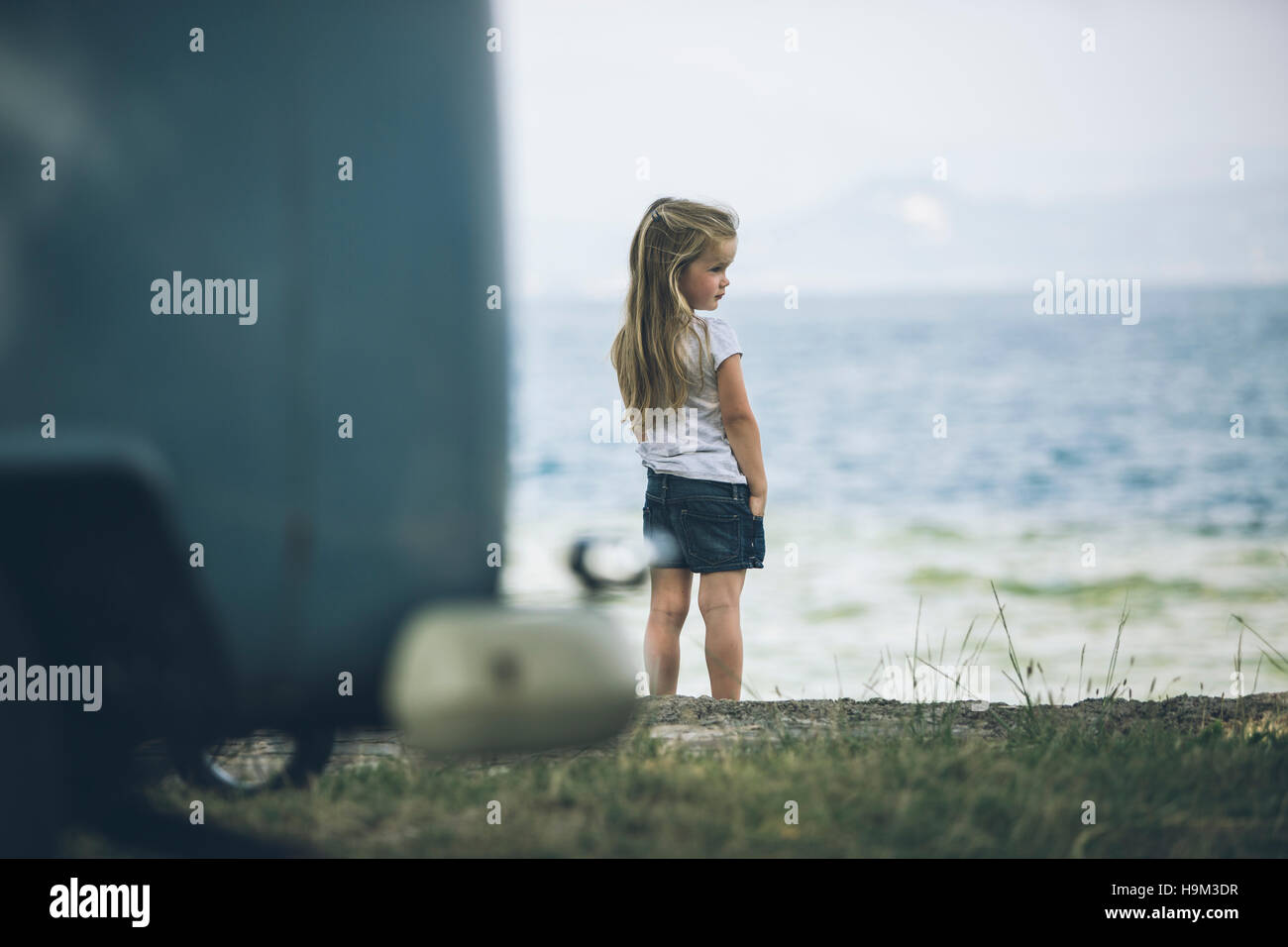 L'Italie, le lac de Garde, Girl standing at lakeshore Banque D'Images L'Italie, le lac de Garde, Girl standing at lakeshore Banque D'Images