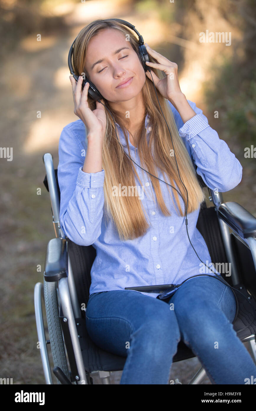 Jeune femme en fauteuil roulant dans le casque Banque D'Images