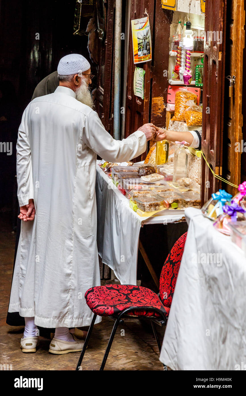 Un homme et sa femme d'acheter des sucreries et des bonbons dans un magasin dans la médina, Fès el Bali, Maroc Banque D'Images