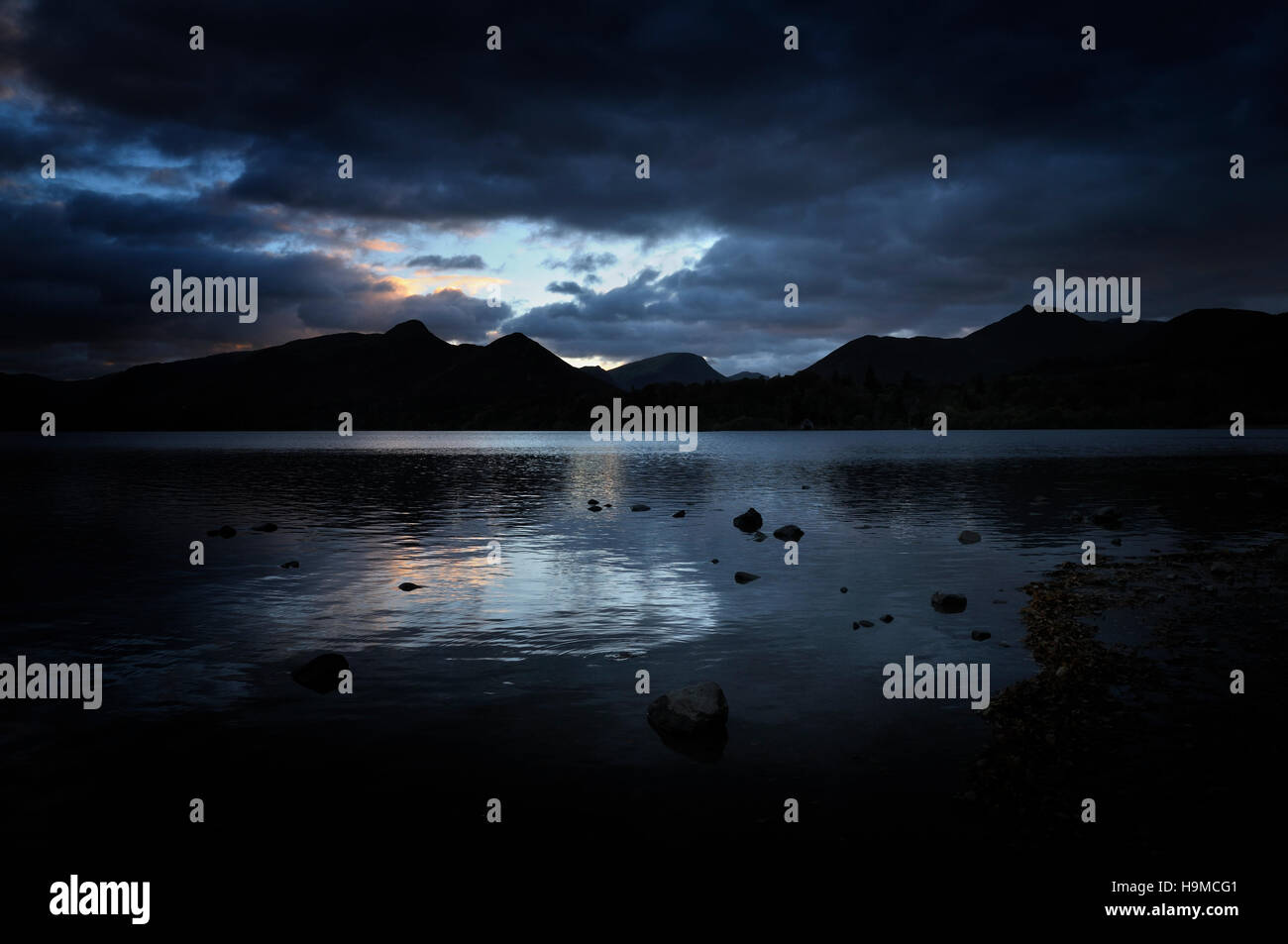La nuit tombe sur les rives tranquilles de Derwentwater, dans le Lake District. (Catbells et Maiden Moor en silhouette.) Banque D'Images