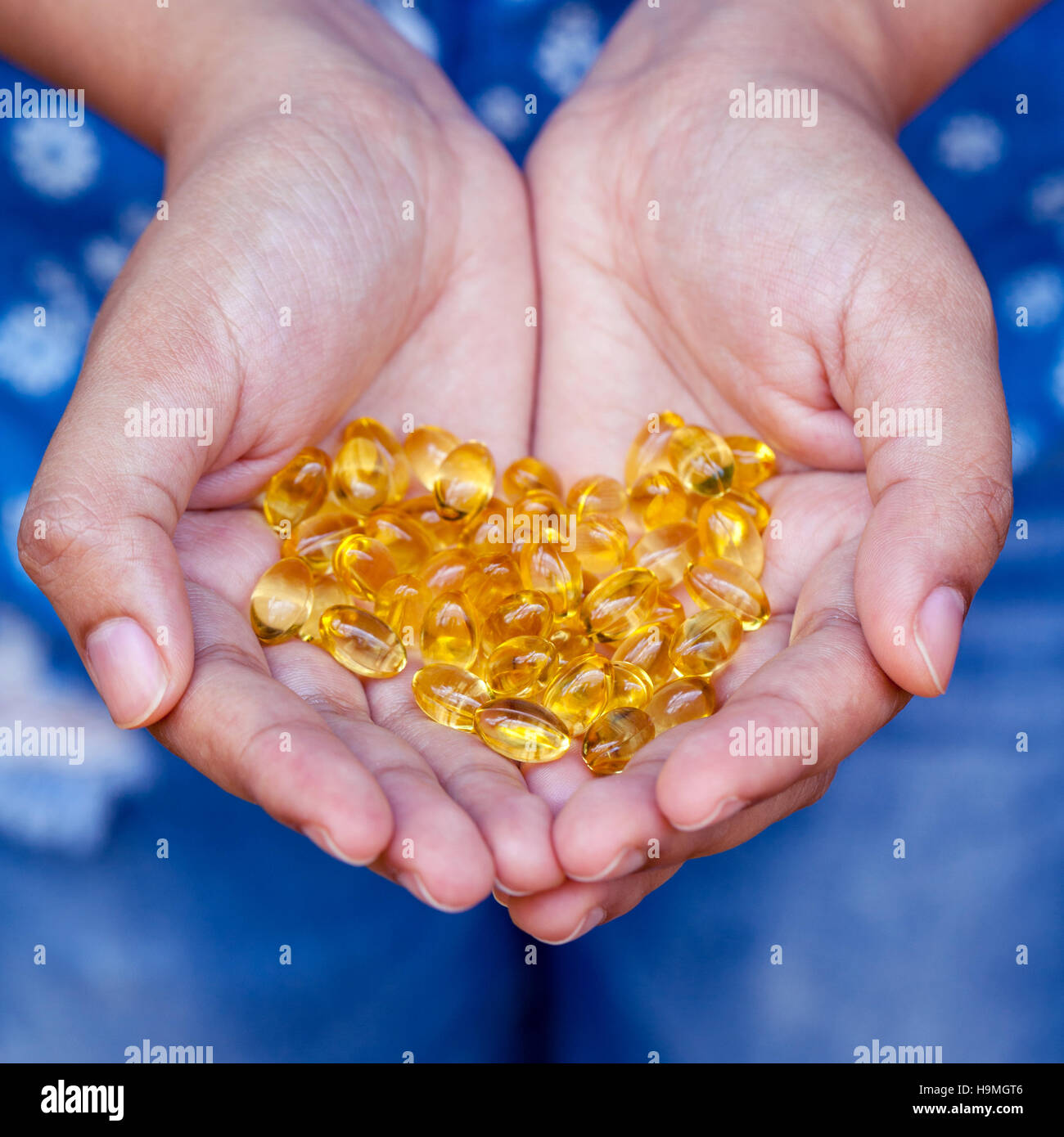 Pilules d'huile de poisson par la jeune fille. Banque D'Images