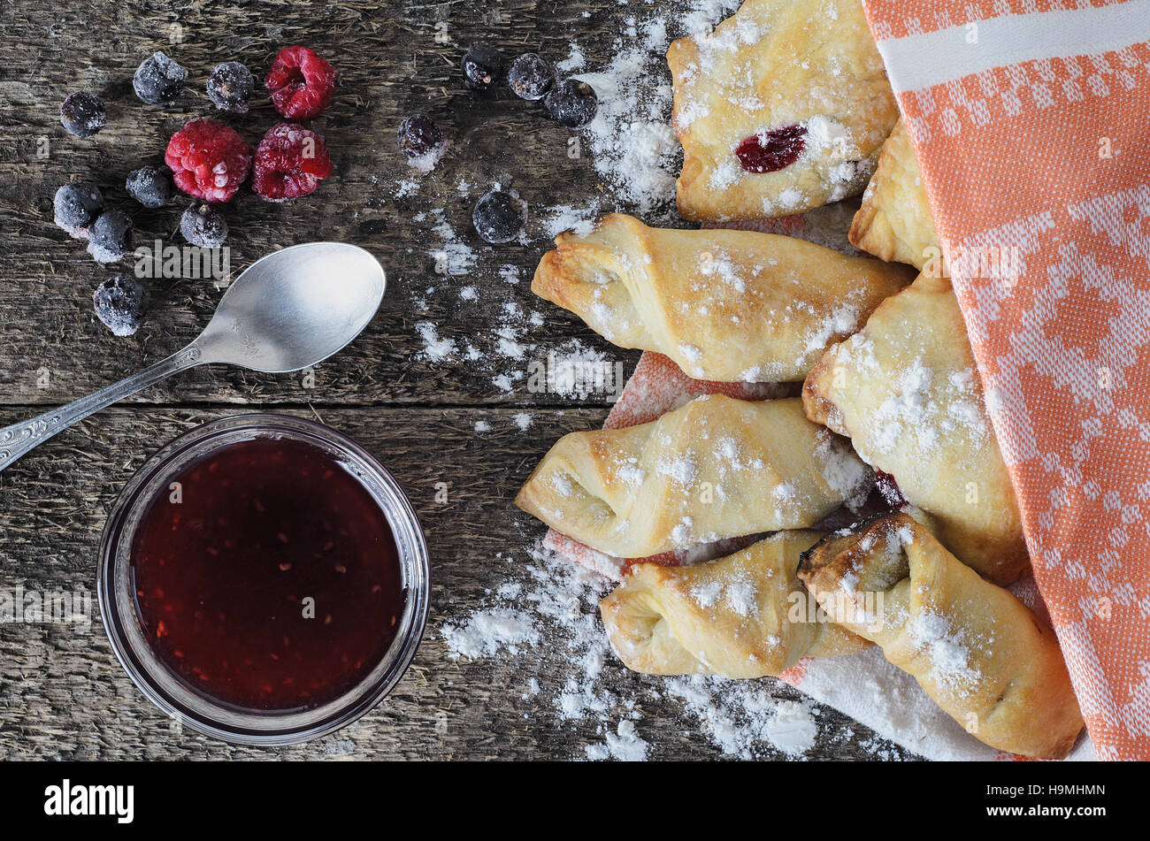 La cuisson avec de la confiture de fruits rouges sur une planche en bois dans un style rustique, décoré avec des baies congelées. Vue d'en haut. Vintage style. La lumière naturelle. La cuisson à la maison. Banque D'Images