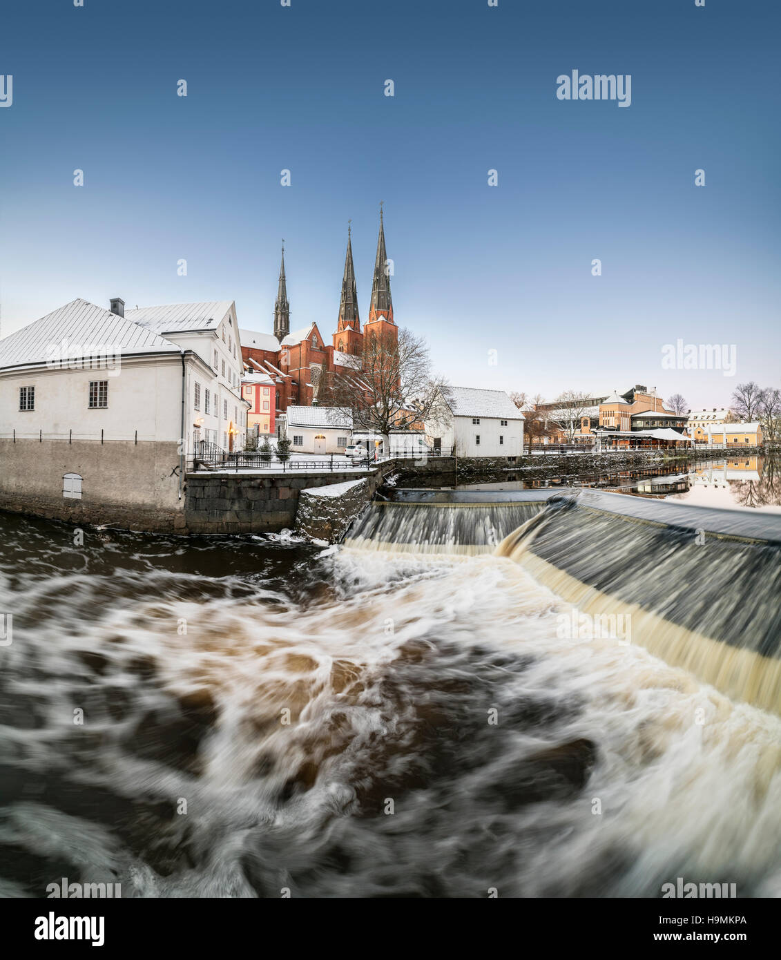 Ancien moulin à Kvarnfallet dans la rivière Fyris avec la Cathédrale (Domkyrkan) dans l'arrière-plan. Uppsala, Suède, Scandinavie Banque D'Images