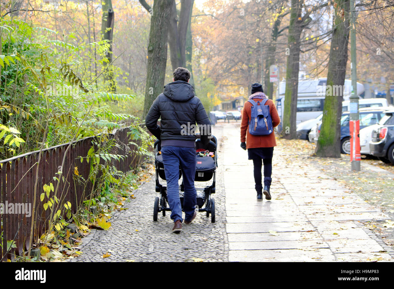 Famille marchant père papa poussant des bébés jumeaux dans une poussette de bébé dans une rue en automne Prenzlauer Berg quartier Berlin, Allemagne, Europe, eu KATHY DEWITT Banque D'Images