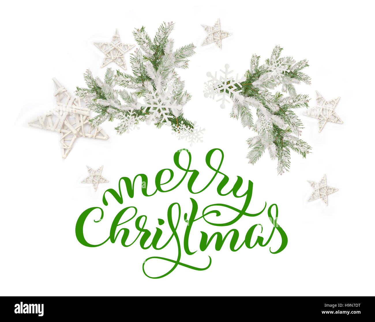 Branches de sapin dans la neige sur un fond blanc et texte de joyeux Noël. calligraphie lettrage Banque D'Images