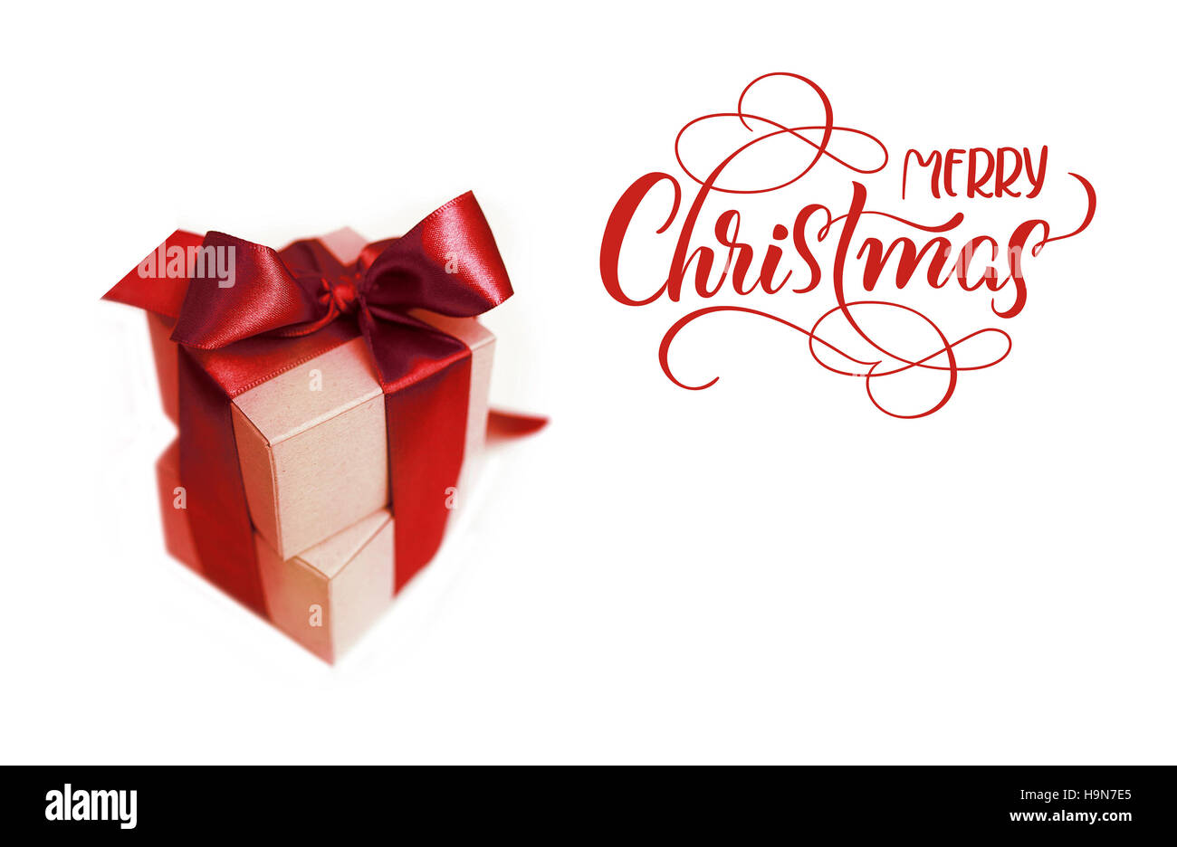 Boîtes cadeaux avec bow brun sur un fond blanc et texte Joyeux Noël calligraphie lettrage. Banque D'Images