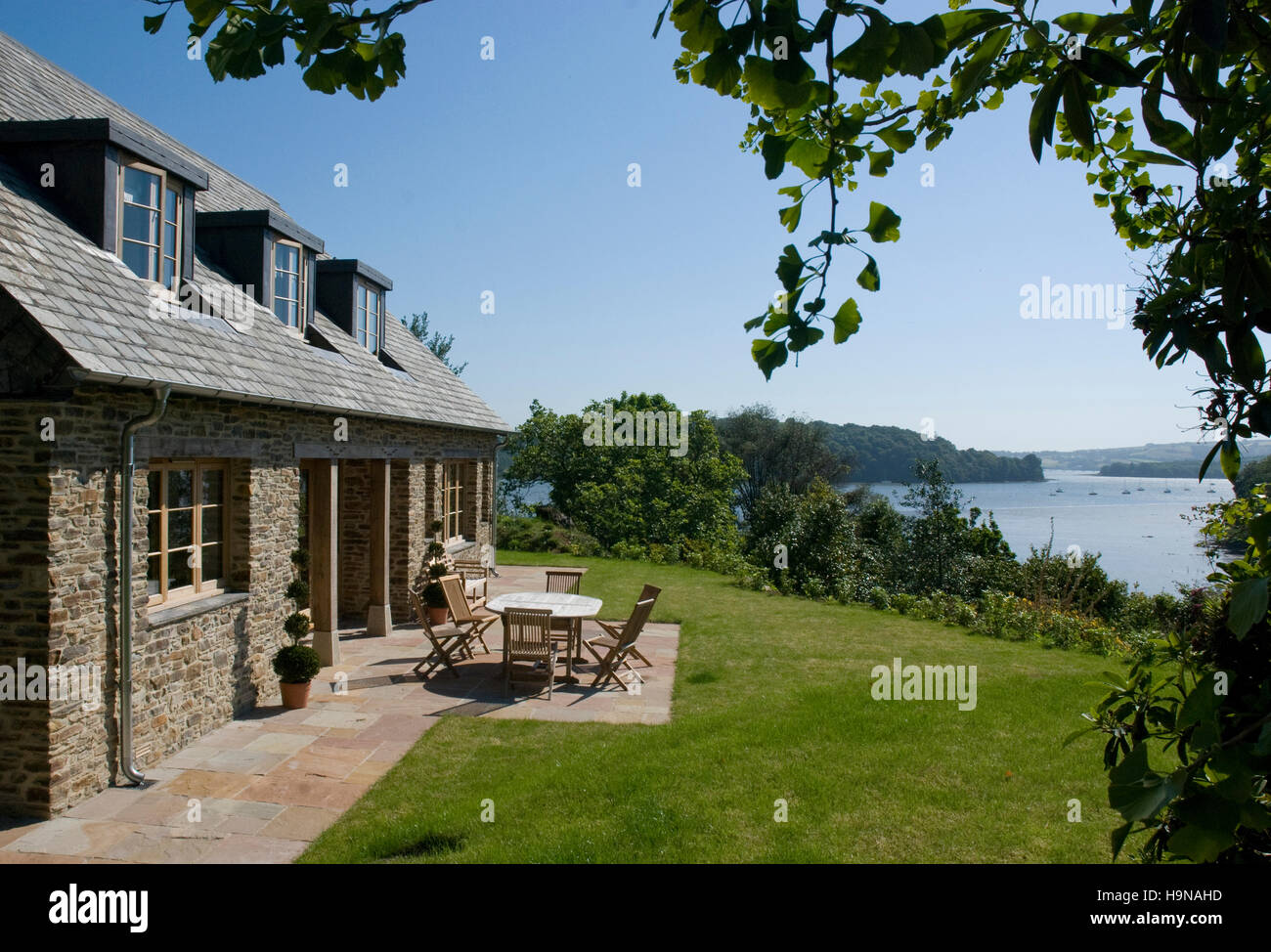 Maison de campagne, vue sur la mer, riverside cottage, table et chaises, l'heure d'été.maison dans le pays. Banque D'Images