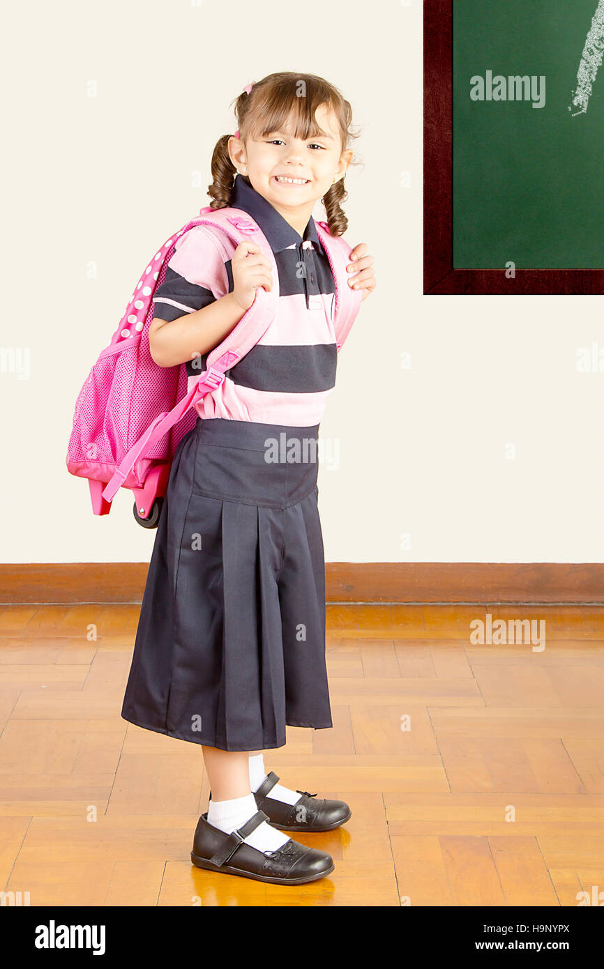 Happy Little School Girl en uniforme à la salle de classe Banque D'Images