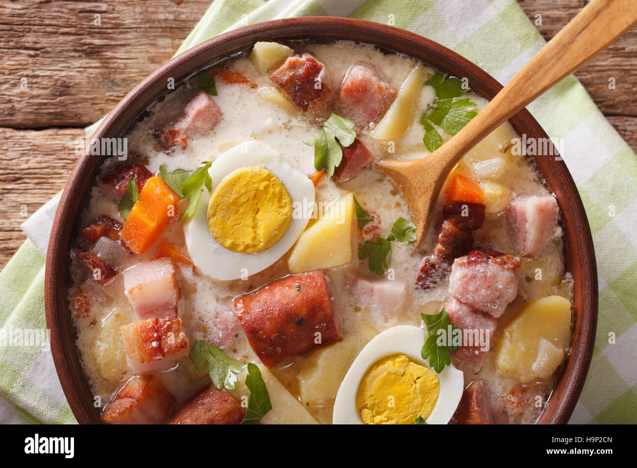Soupe Zurek polonais avec de la saucisse, les légumes et les œufs dans un bol sur la table horizontale vue du dessus. Banque D'Images