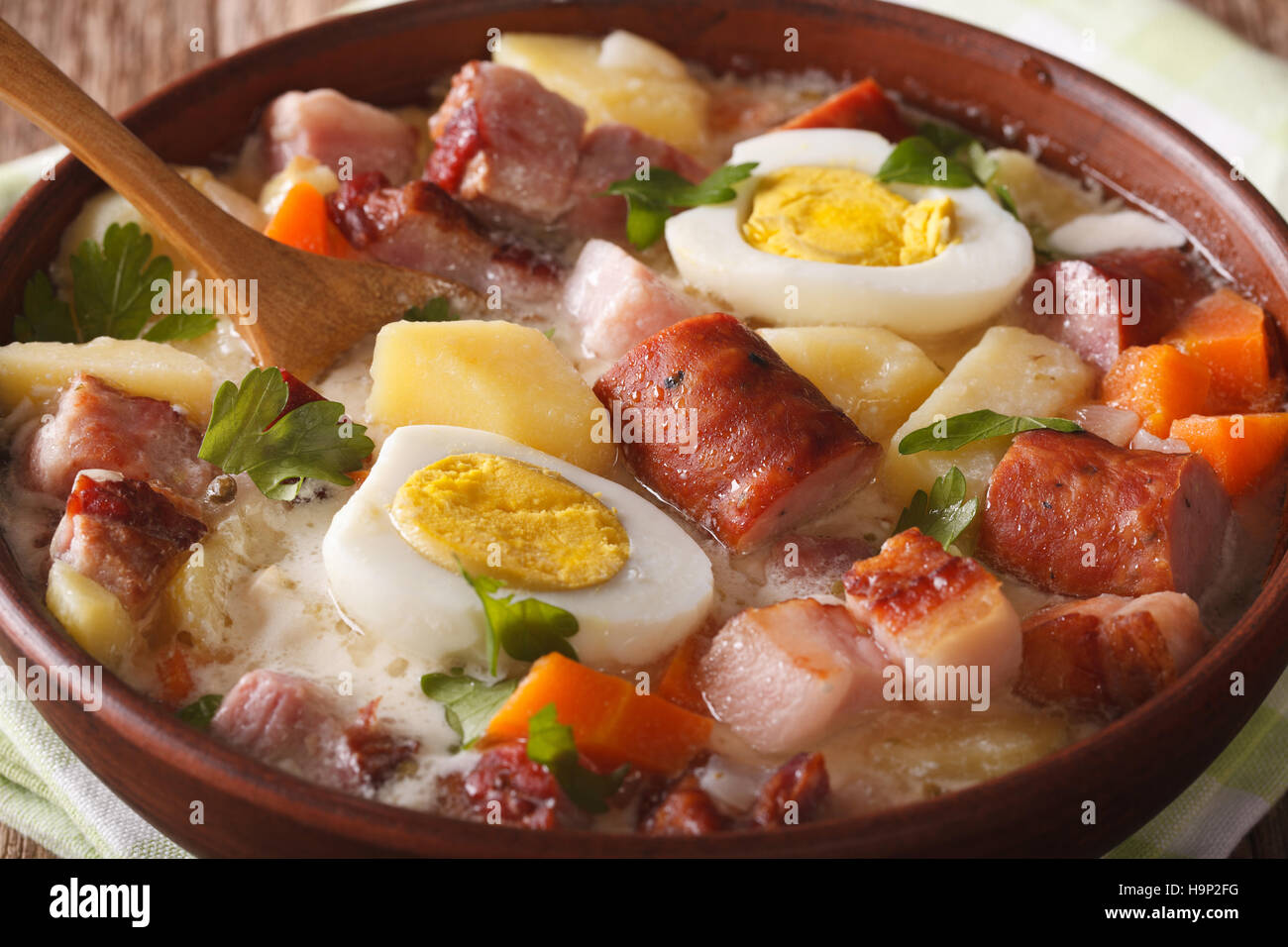 Soupe Zurek polonais traditionnels avec la saucisse dans un bol horizontal macro. Banque D'Images