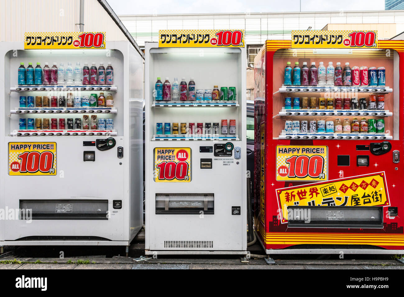 Japon, Osaka, Shinsekai. Trois des distributeurs de boissons, 2 blanc, 1 rouge, en ligne dans la rue. Tous avec des signes montrant : à 100 yen. Vue de face. Banque D'Images