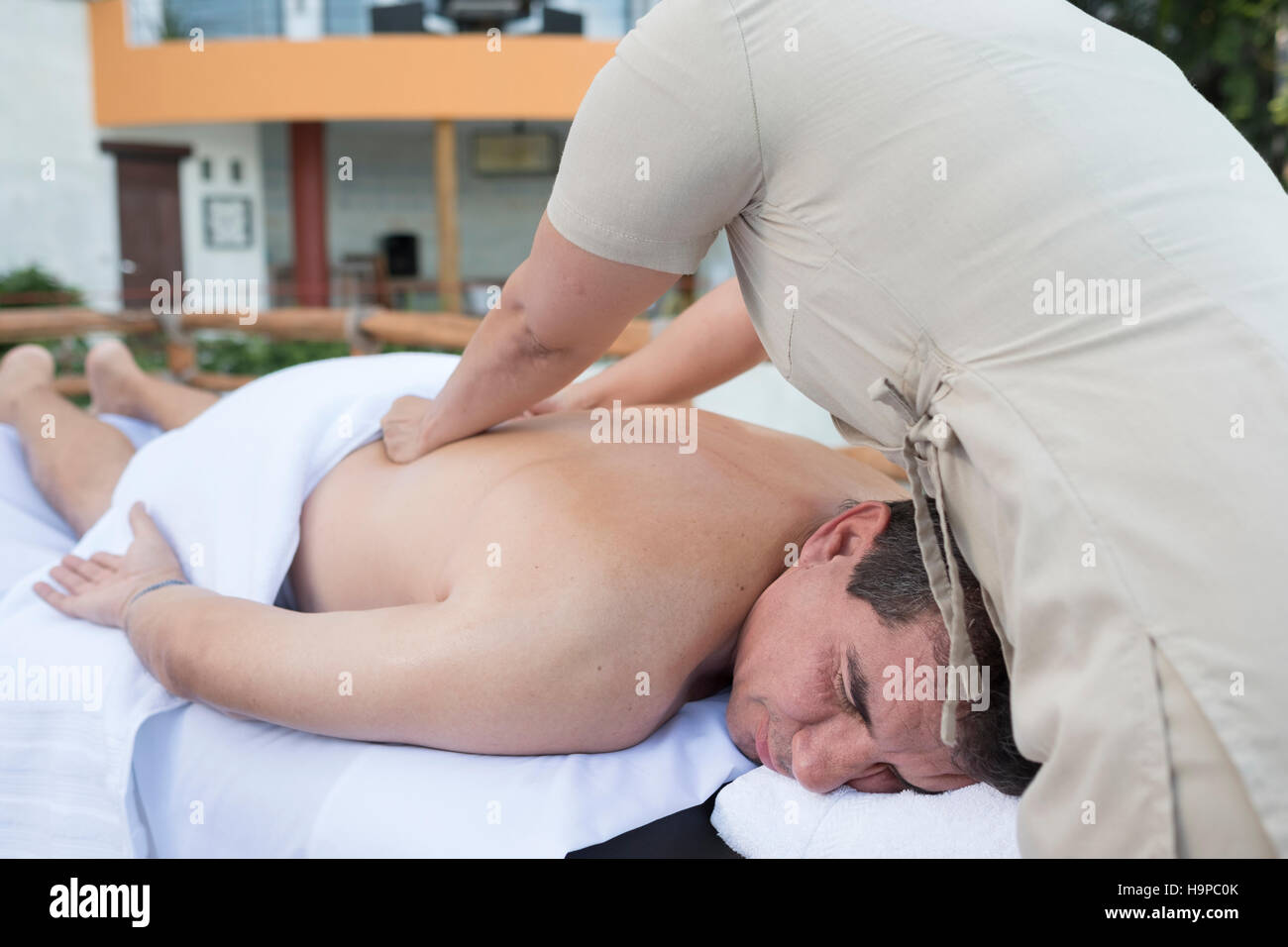 Un homme a les yeux fermés, profitant d'un massage en plein air à la retraite bien-être au Mexique. Banque D'Images