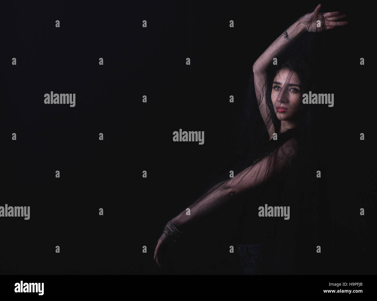 Femme posant dans le studio sur fond sombre Banque D'Images
