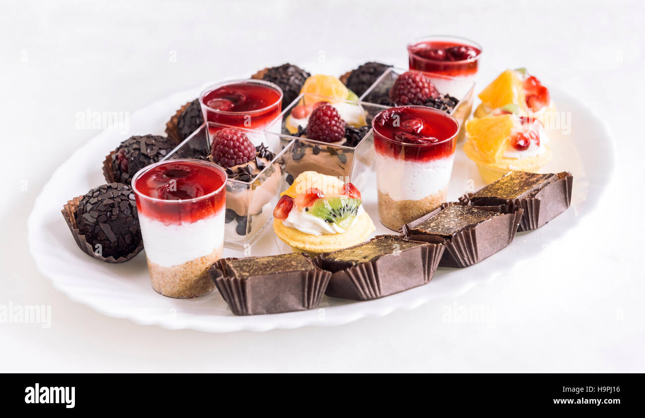 Assortiment de mini cakes servis sur assiette blanche, selective focus Banque D'Images
