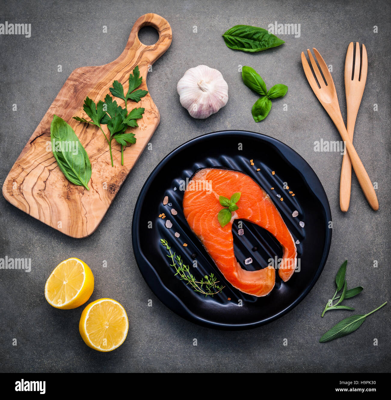 Filet de saumon cru dans la plaque noire avec des ingrédients l'huile d'olive Banque D'Images