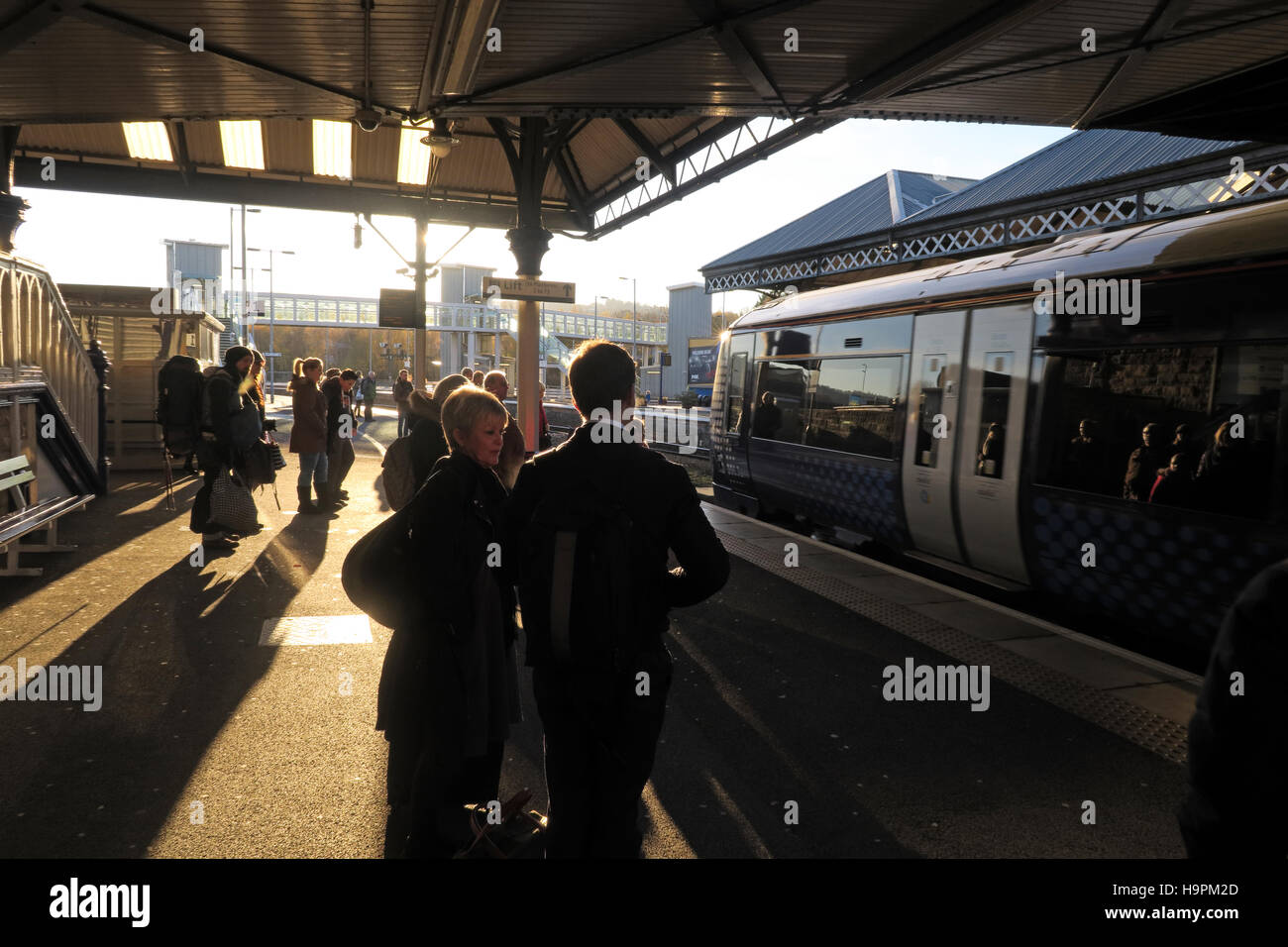 Les passagers casting shadows sur une plate-forme ferroviaire, Perth, Ecosse, Royaume-Uni Banque D'Images