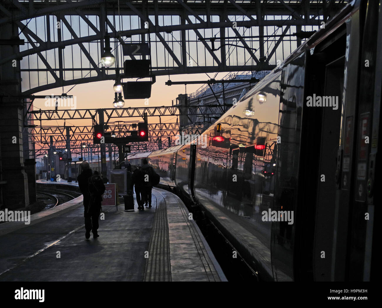 Gare centrale de Glasgow - passagers de plateforme au crépuscule à bord du train principal de la côte ouest Avanti Tren-Italia WCML Banque D'Images