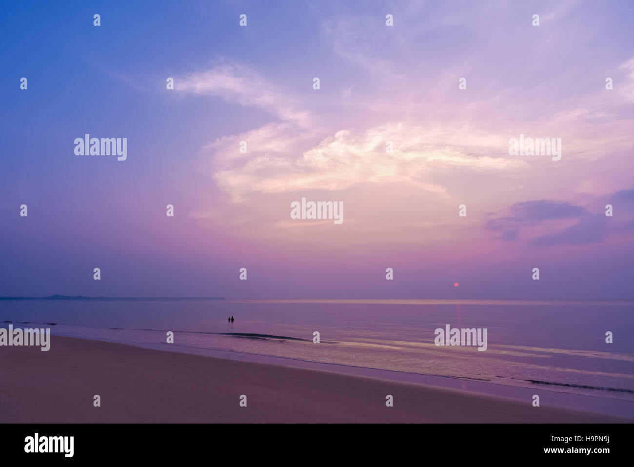 Coucher de soleil romantique, doux, coloré ciel nuage magique et un couple au Tropical Beach. Banque D'Images