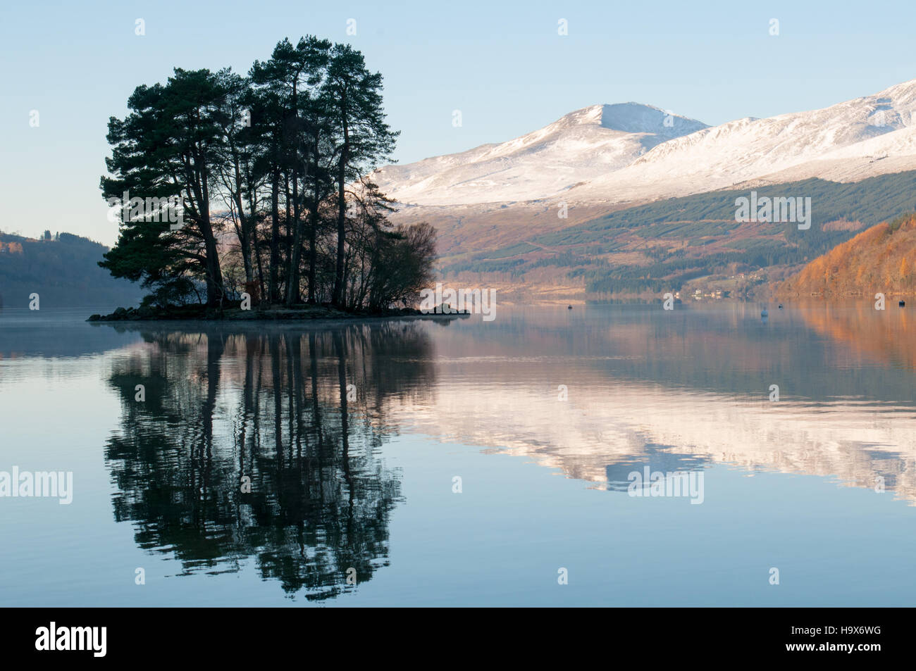 Le Loch Tay, Kenmore, Perthshire, Écosse, Royaume-Uni, avec le soleil qui brille sur les montagnes enneigées de la gamme Lawers dans l'arrière-plan Banque D'Images