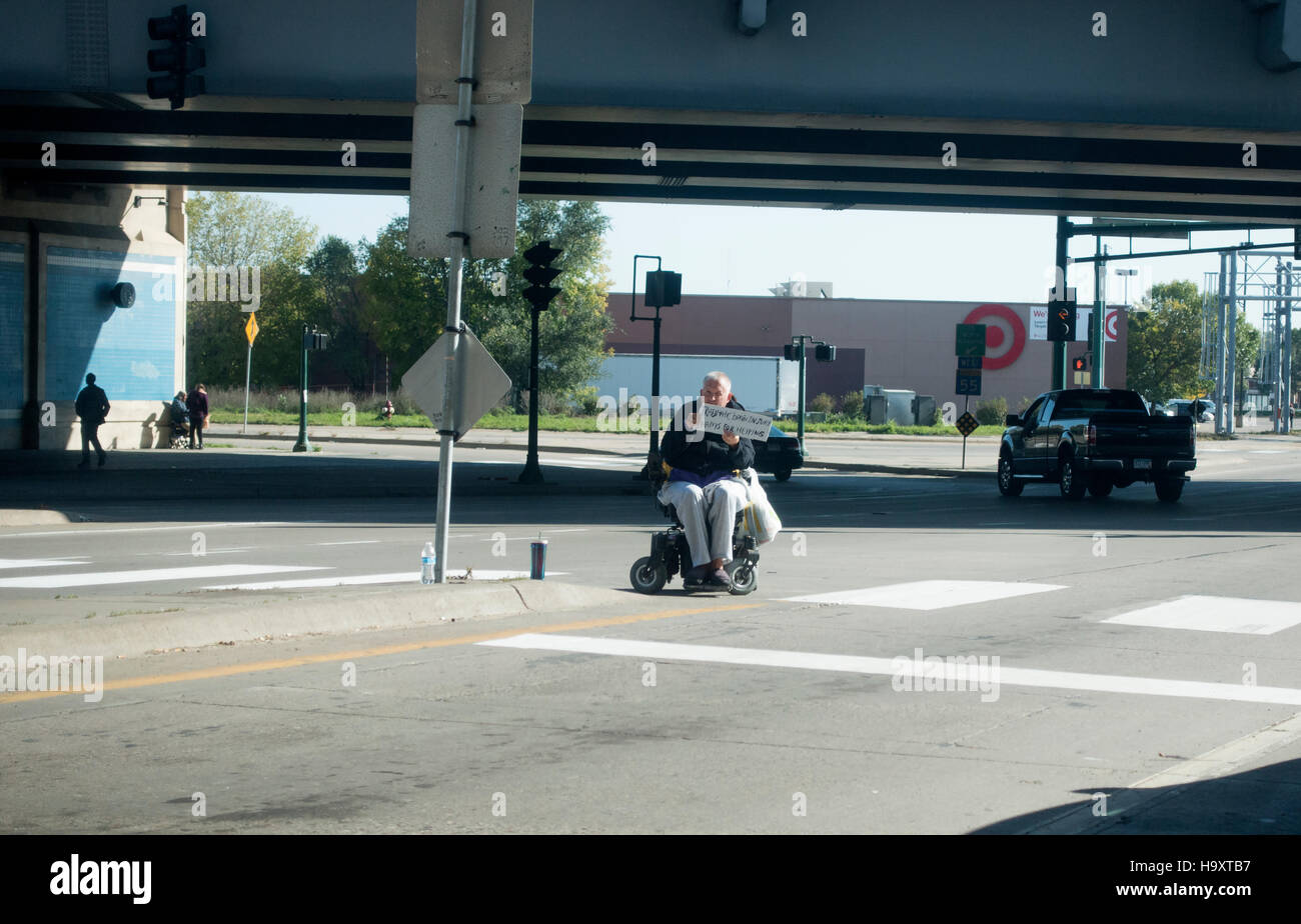 Handicapped man in wheelchair holding panneau disant qu'il souffre de "traumatisme crânien". Minneapolis Minnesota MN USA Banque D'Images