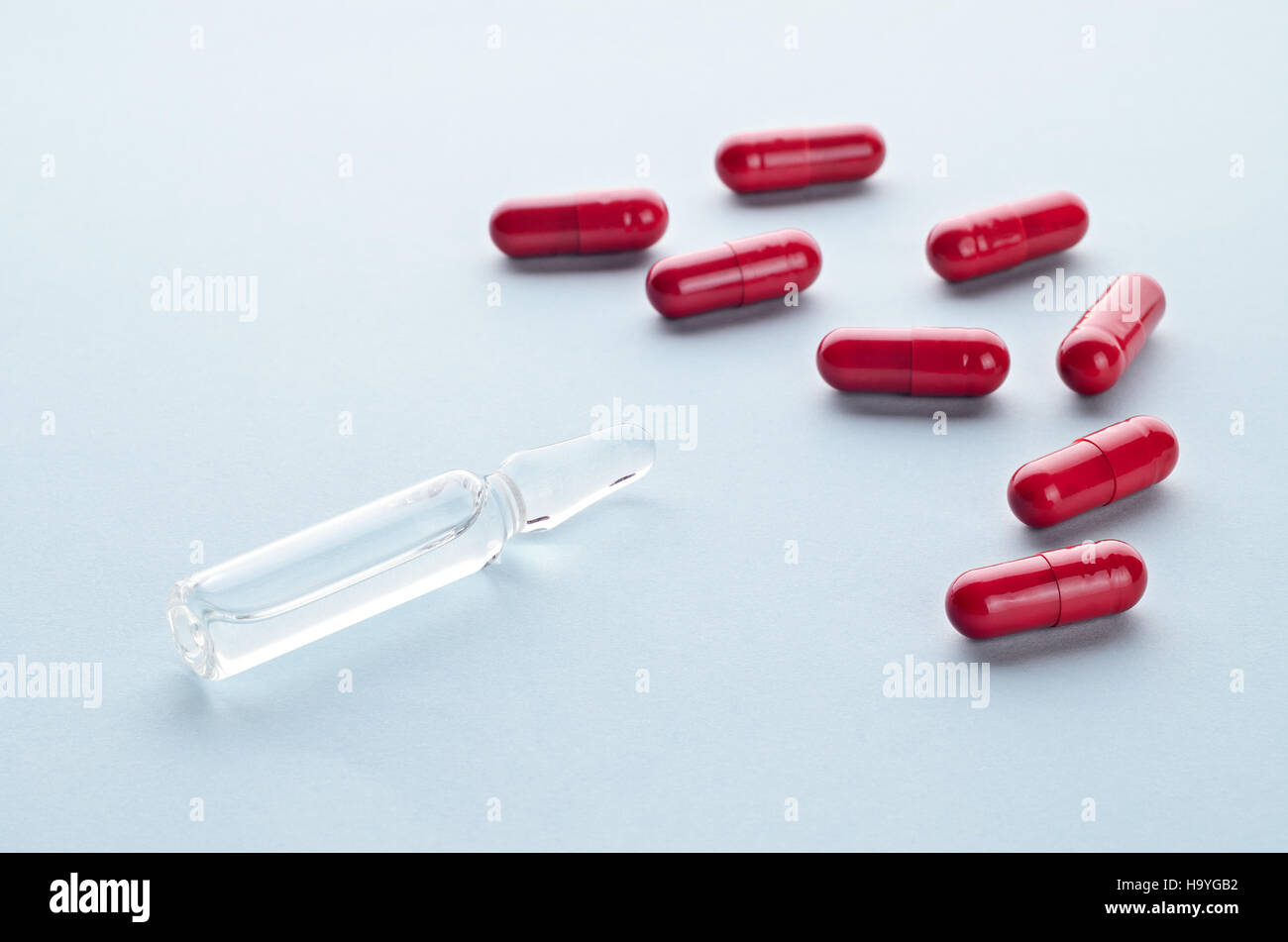 Capsules comprimés colorés assortis et ampoule sur un fond clair close up, horizontal, copy space, selective focus, concept médical. Banque D'Images