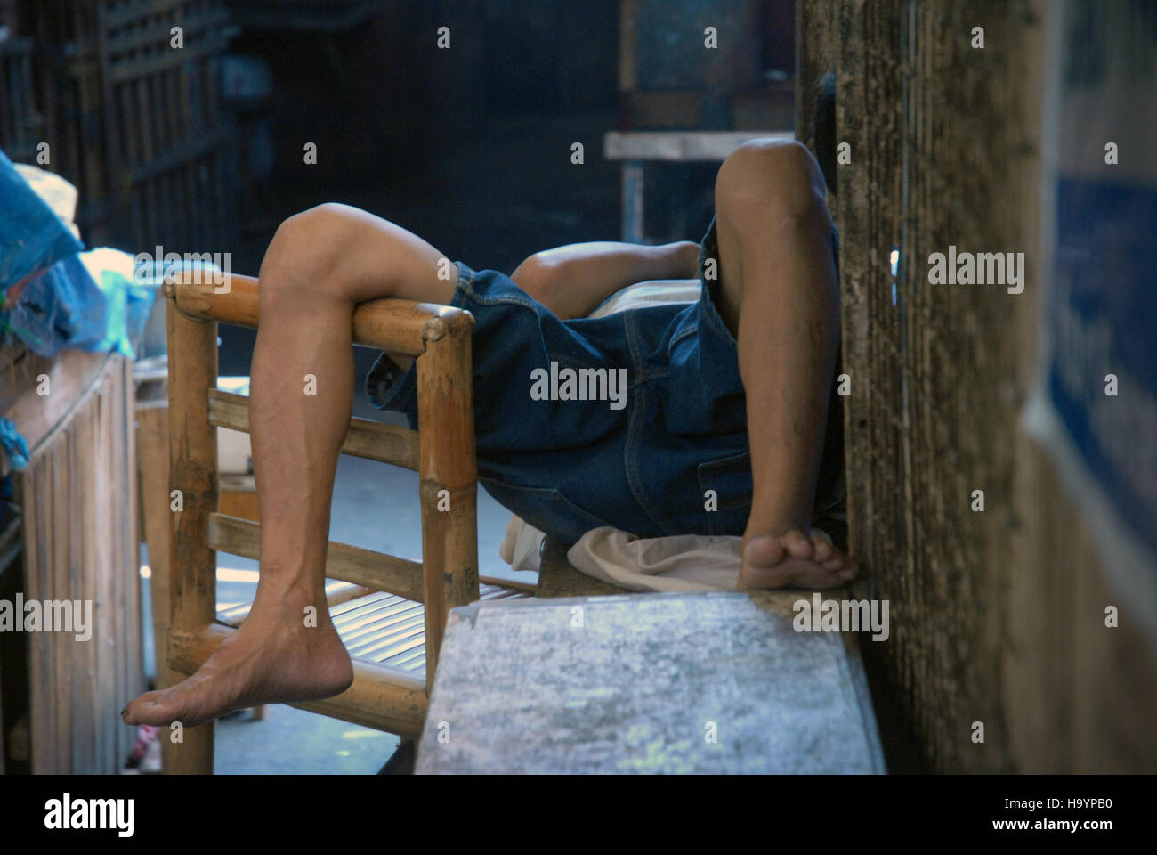 Vieil homme endormi sur un banc à l'intérieur du marché Central, Iloilo, aux Philippines, Panay. Banque D'Images