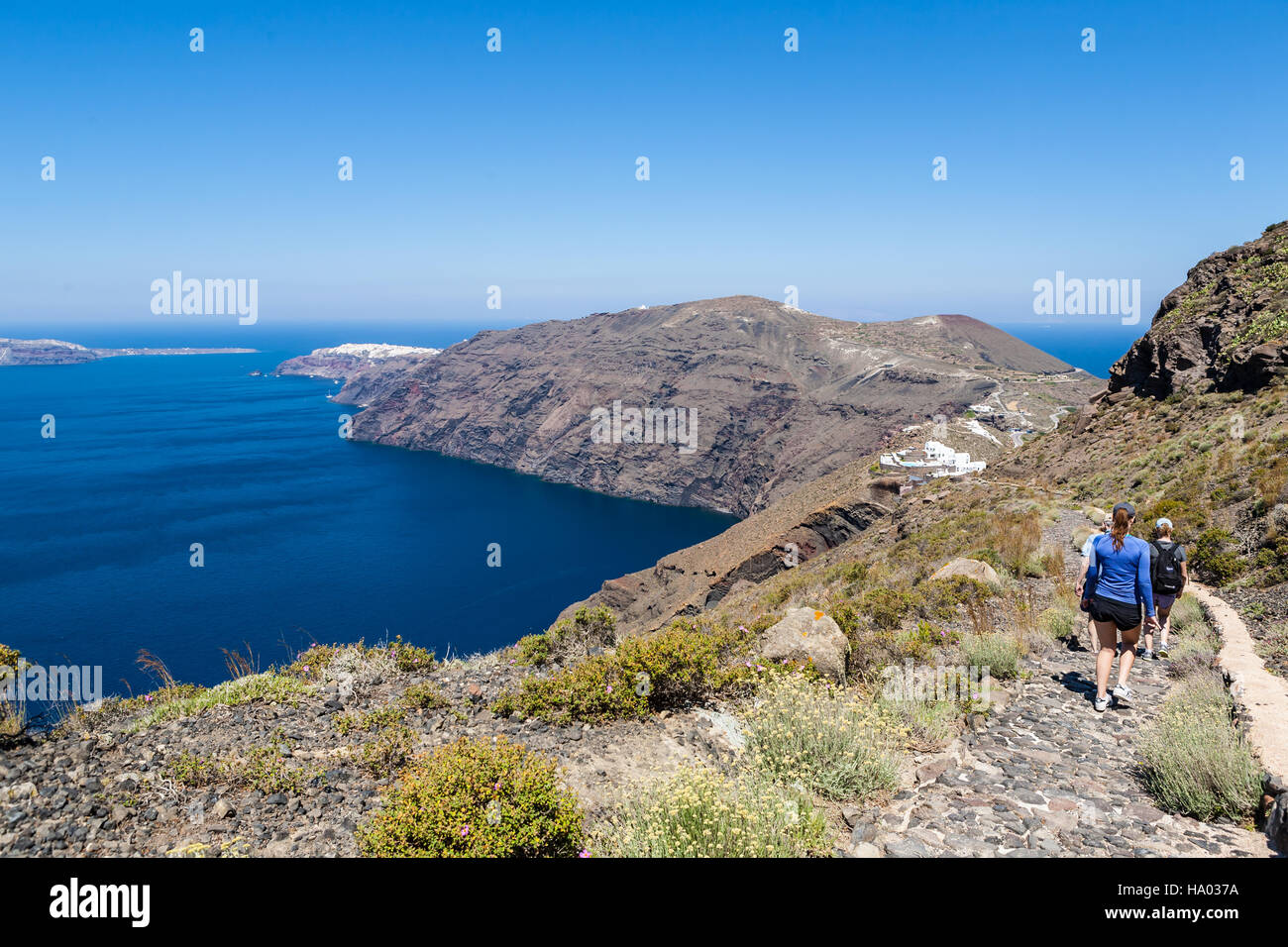 Les Randonneurs marchant le long de la rim volcan entre Fira et Oia sur l'île grecque de Santorin par un beau jour ensoleillé chaud Banque D'Images